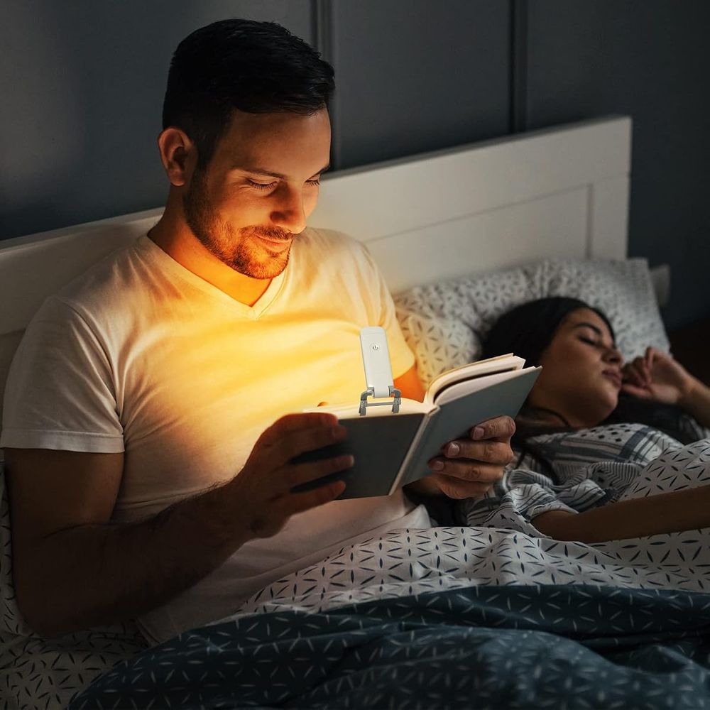 Reading in bed with the DEWENWILS amber book light without waking a sleeping partner