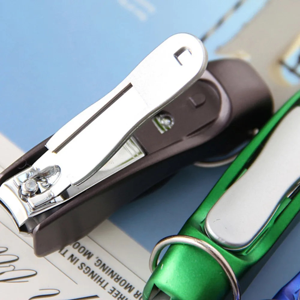 Close-up of the pen keychain's stainless steel nail clipper swung open, with a green unit resting behind it