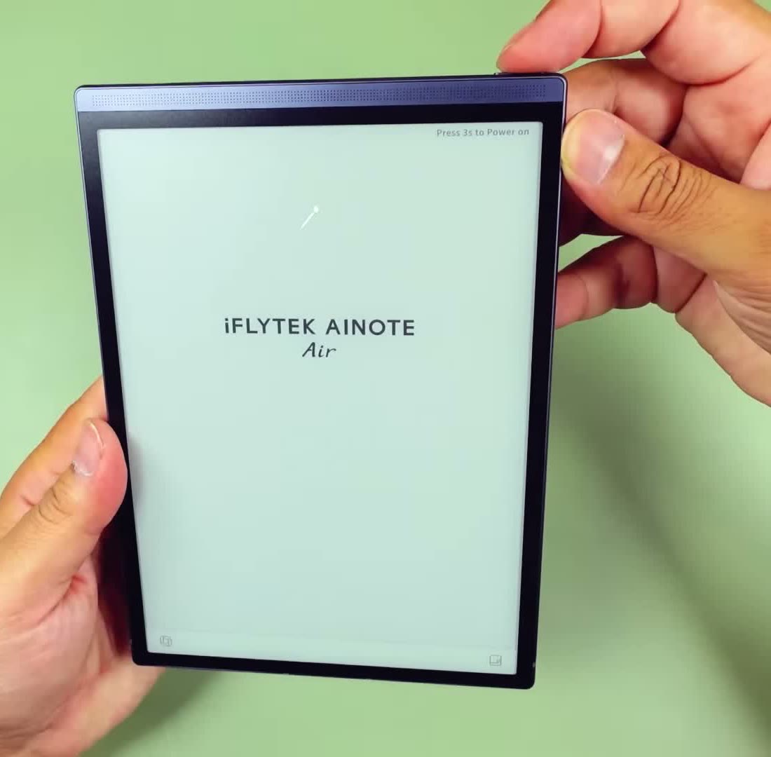 iFLYTEK AINOTE Air 2 E Ink tablet held in one hand, startup screen showing the AINOTE Air logo