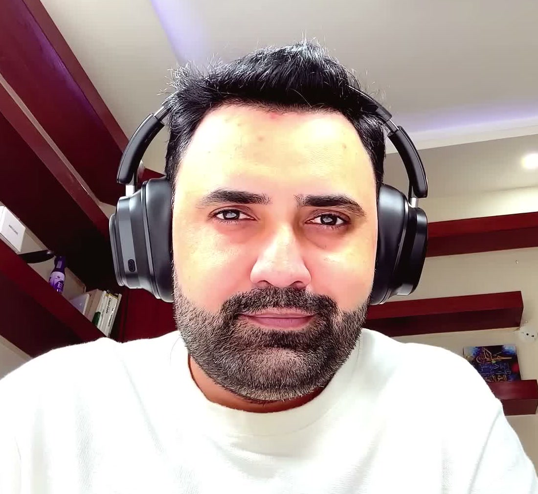 The headphones being worn on camera, showing how the earcups sit over the ears and the size of the headband