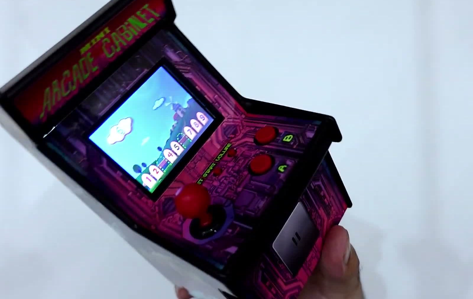 The console tilted to show its cabinet shape, marquee and side panel while a game runs