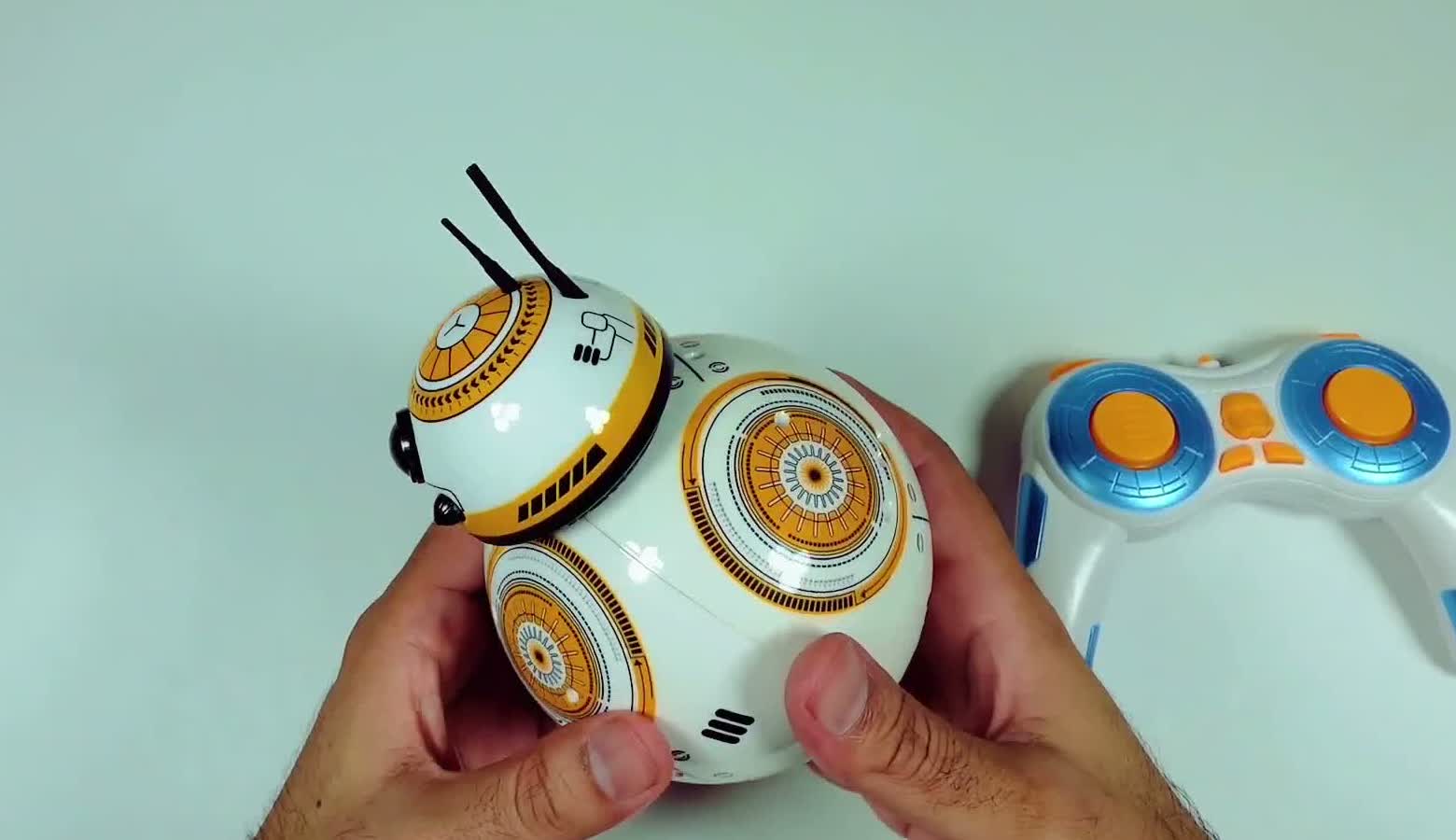 The assembled droid toy beside its blue and orange 2.4GHz remote control handset