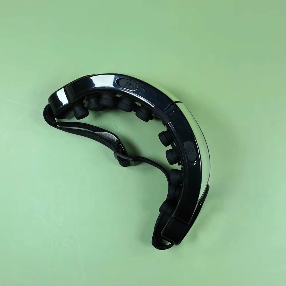 Oaks smart eye massager lying folded on a plain table, showing the curved gloss housing, the soft rubber acupressure nodes and the adjustable head strap