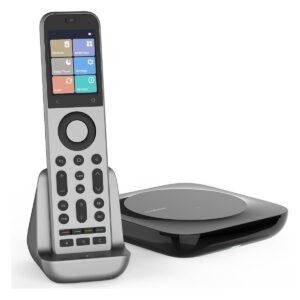 Silver SofaBaton X2 universal remote with a colour touchscreen, standing upright in its black charging dock