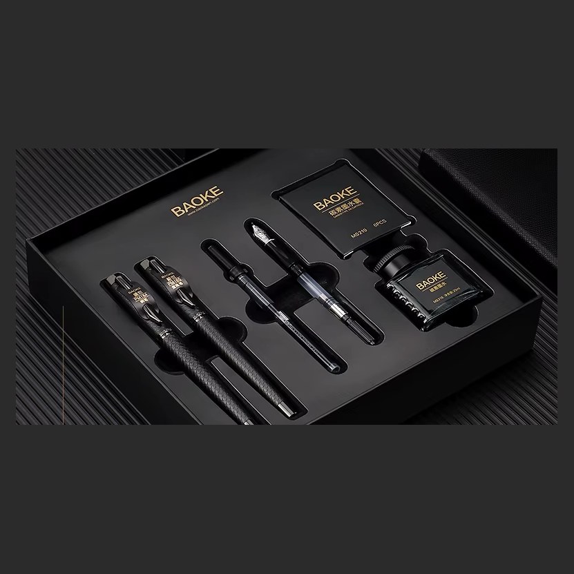 Open black BAOKE gift box holding four fountain pens, a boxed ink bottle and a spare cartridge pack in fitted foam