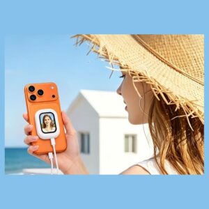 Woman in a straw hat holding an orange phone with a small white selfie monitor magnetically attached to the back, showing her live preview