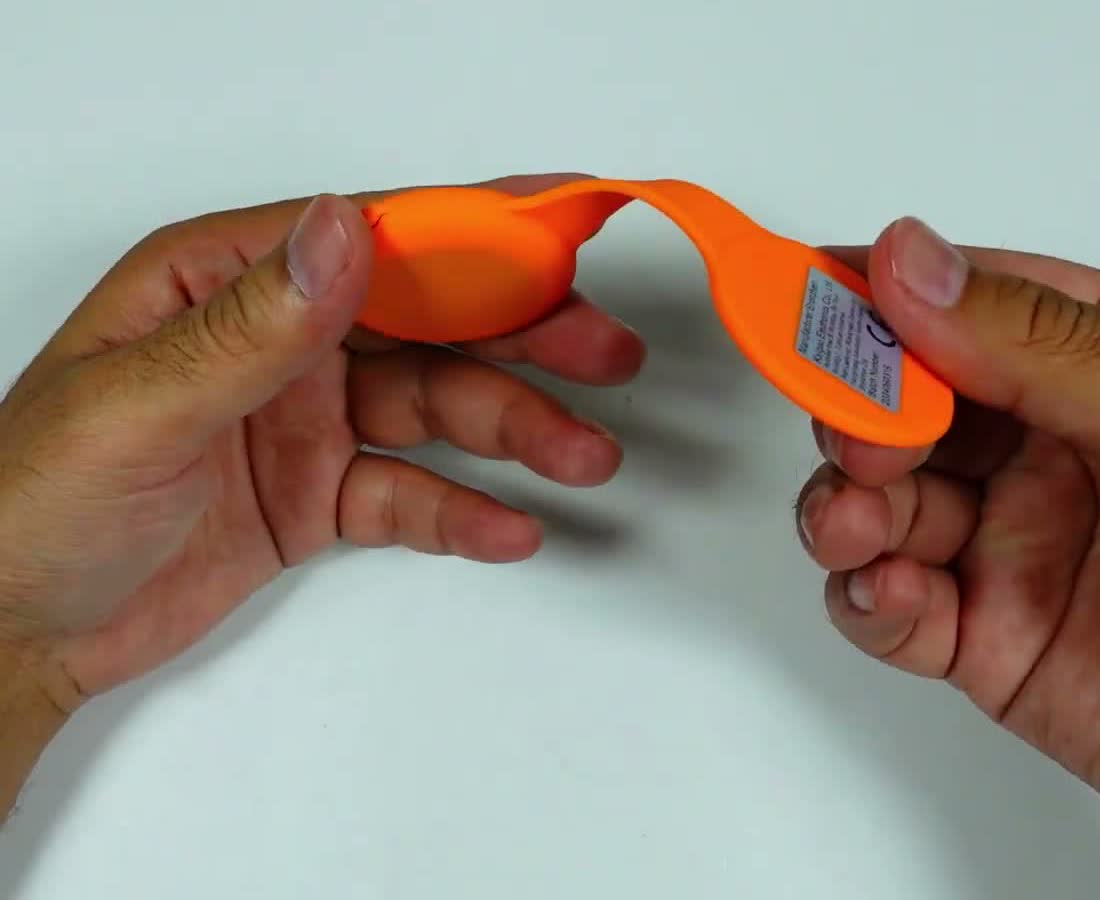 The flashlight's flexible silicone strap being bent by hand during the review