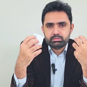 The LensGo 318C Mark 2 wireless transmitter held up beside the reviewer's face