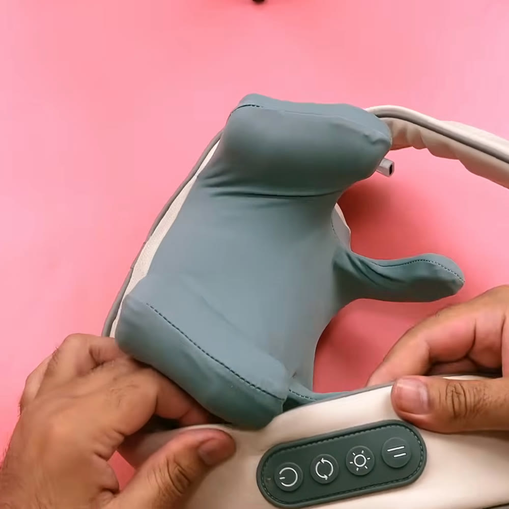 Underside of the neck and shoulder massager held in two hands, showing the four-button control panel on the cream housing