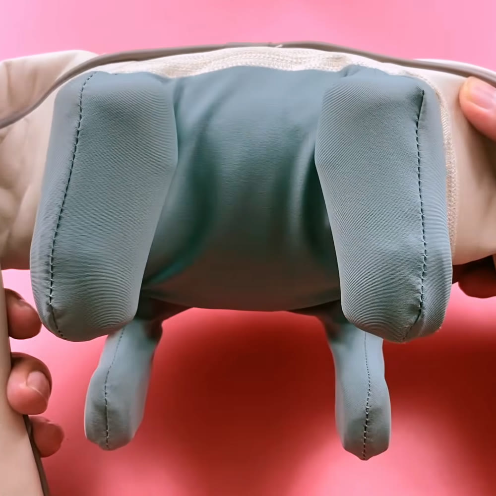 Close-up of the cream Morelax neck massager showing its four sage-grey kneading heads and stitched fabric covers