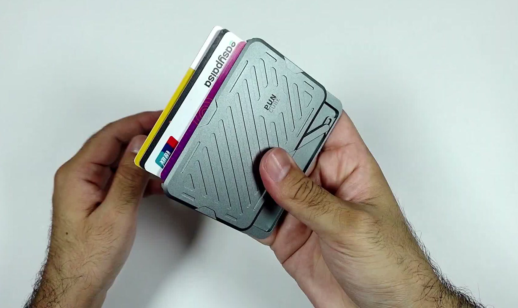 The wallet held in both hands with a stack of bank cards fanned out of its side