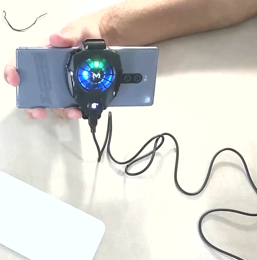 The phone cooler clipped to the back of a phone with its blue LED ring lit
