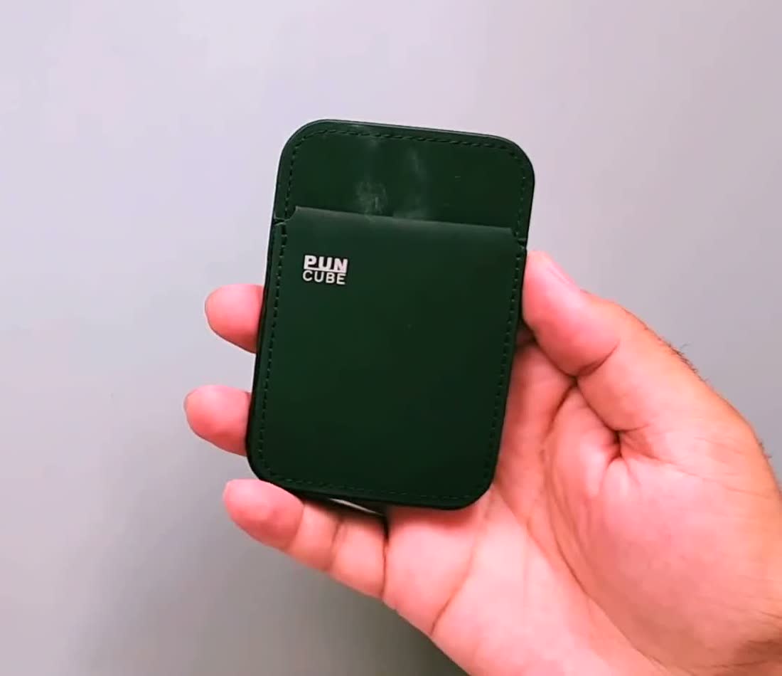 The actual dark green PUNCUBE Minimal Wallet 3.0 held in hand, showing its card pocket
