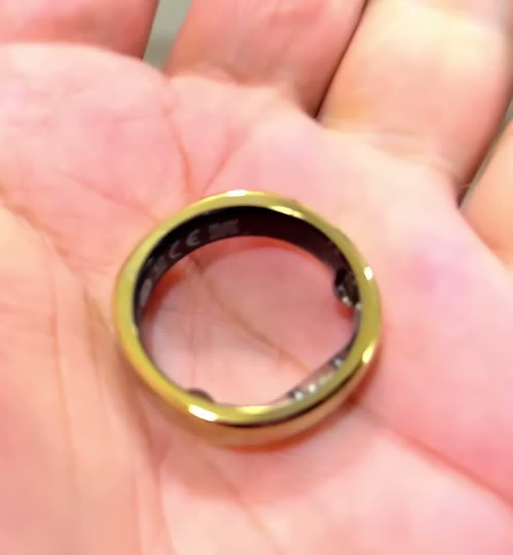 RingConn Gen 3 smart ring in royal gold resting in an open palm, sensor array visible inside the band