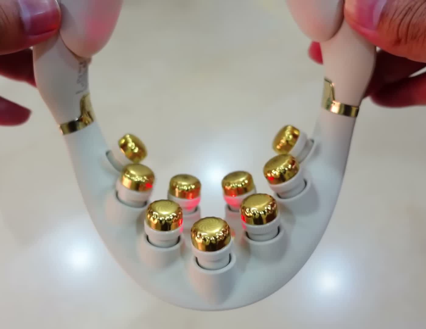 The nine gold titanium-coated massage heads of the SKG G7 Pro, lit red during a session