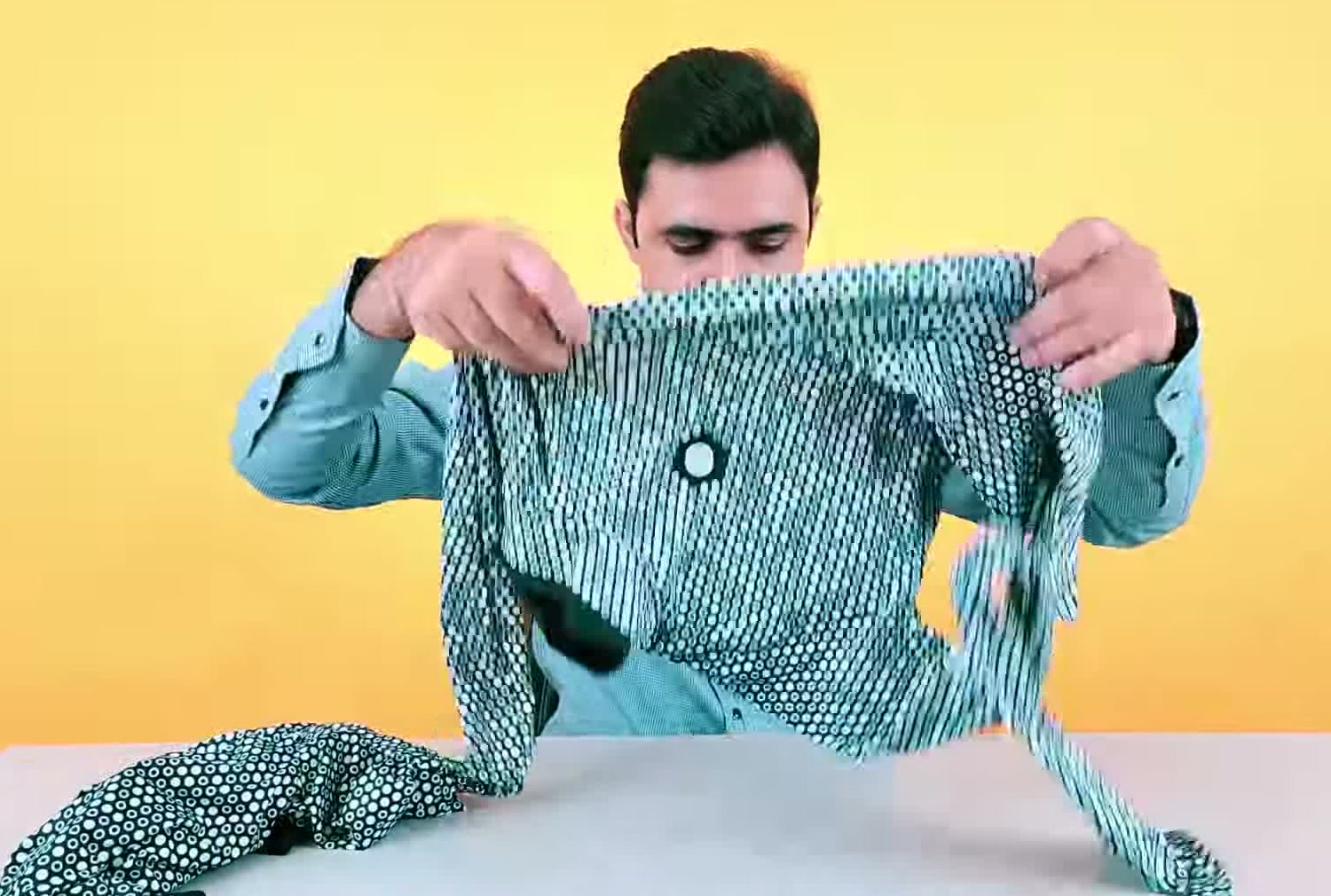 The Zozofit suit's marker-printed top held up by hand, showing the dotted pattern the app tracks
